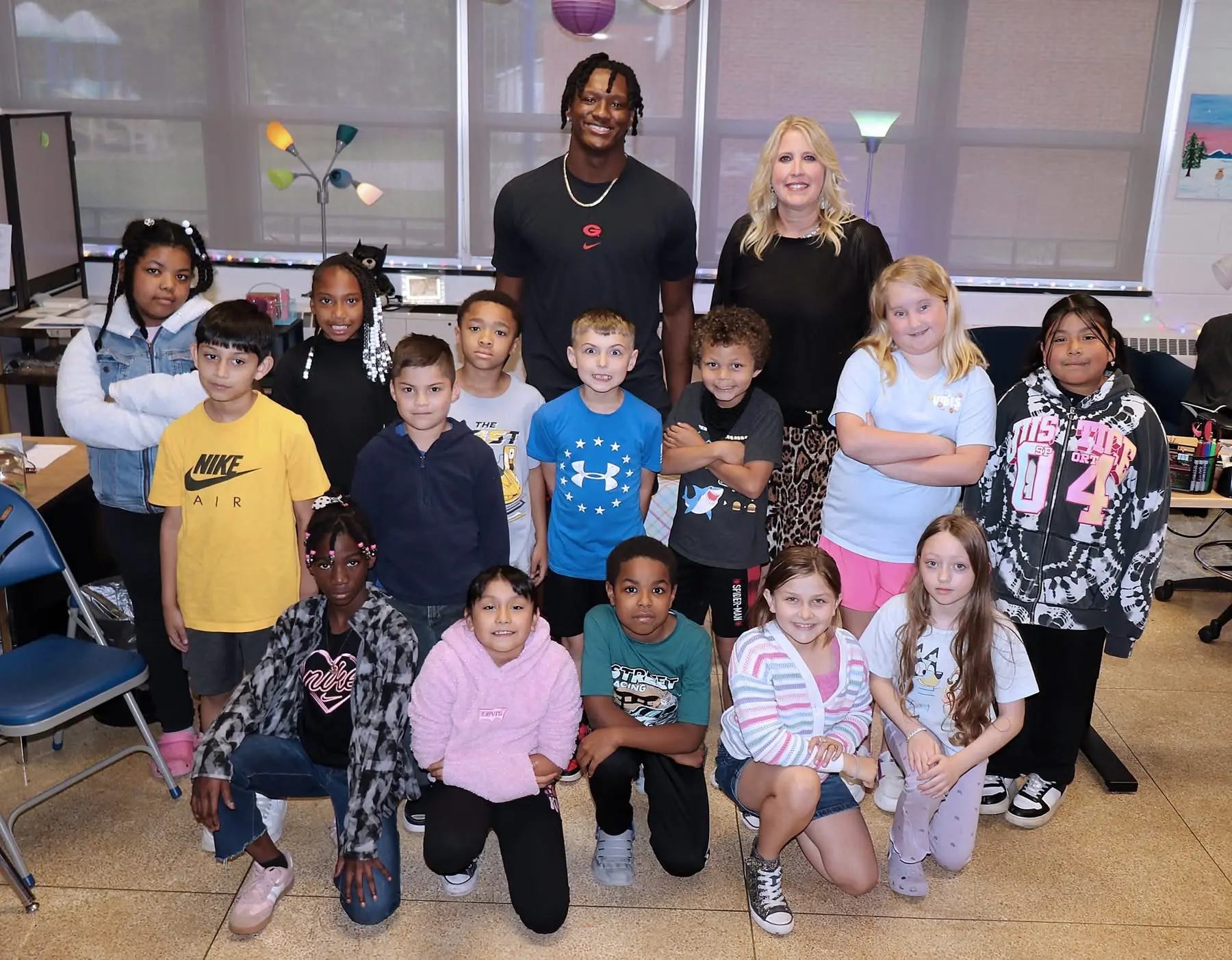 Chris Cole and a teacher with a classroom of elementary students